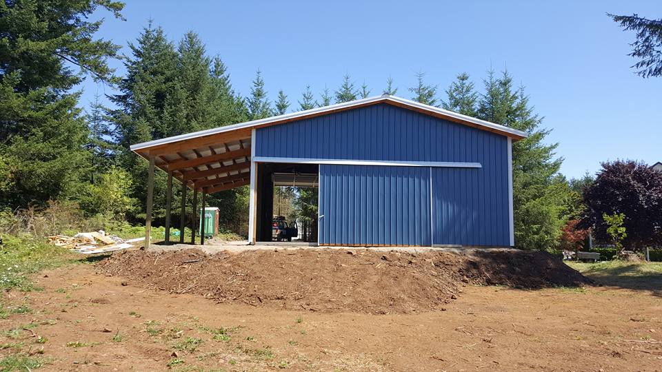 Picture of a large blue pole building with a lean-to on the side.