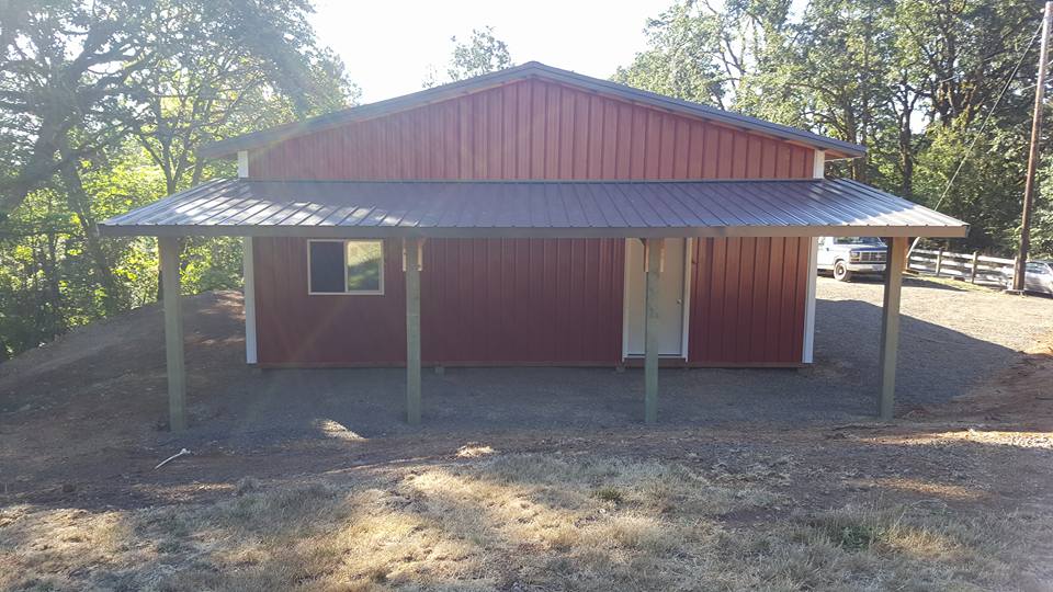 Picture of a red pole barn built with an awning.