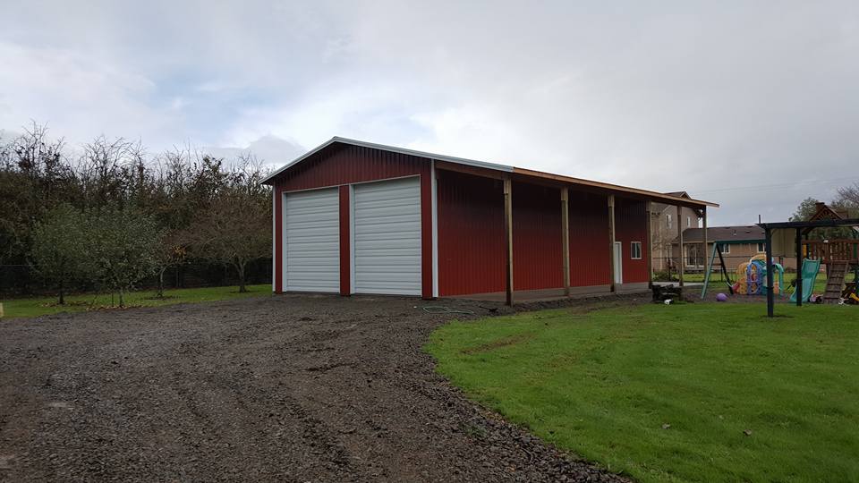 Picture of a large red pole building with two overhead doors and a lean-to.