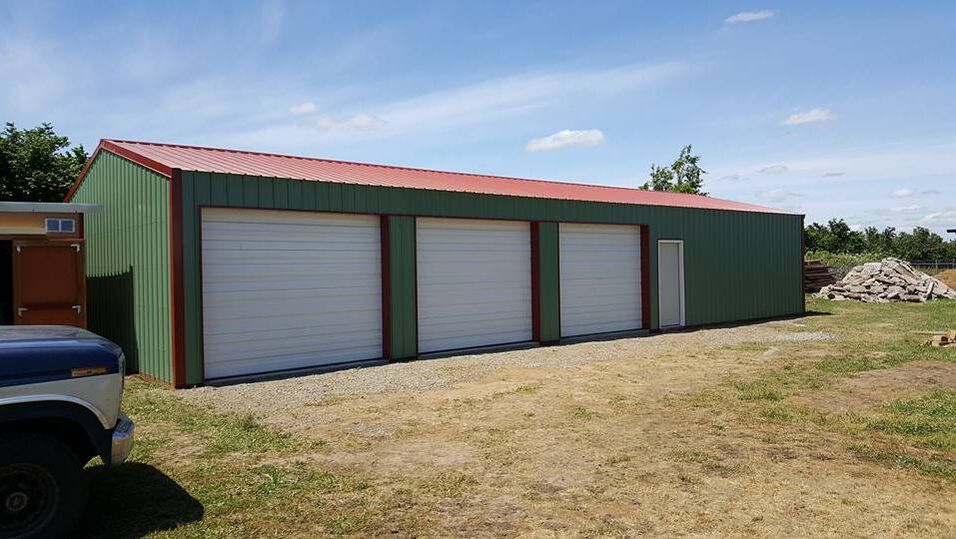 Picture of a green pole building with 3 large slider doors.