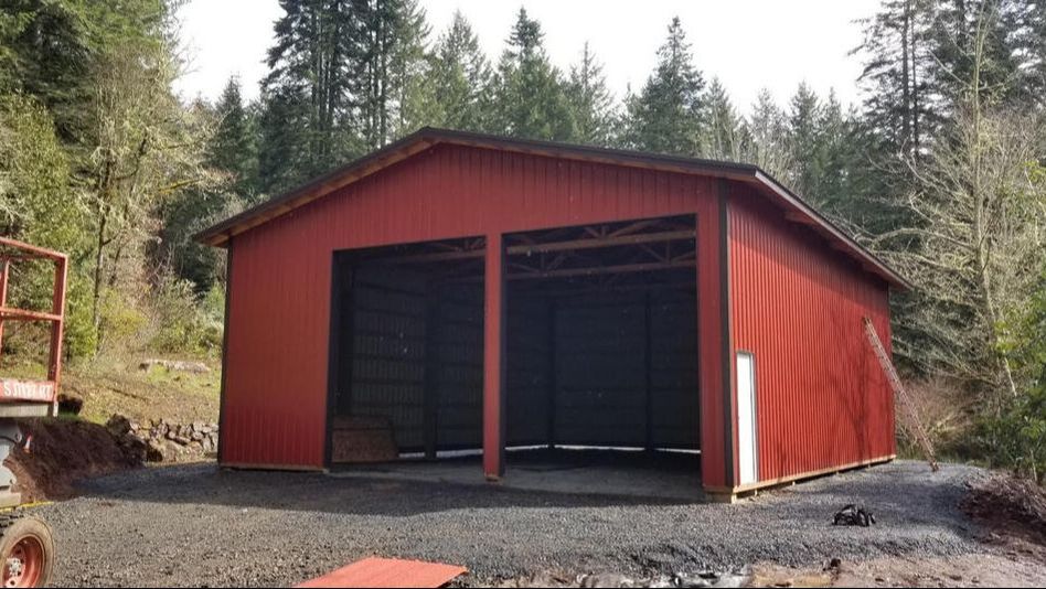 Picture of a large red pole building with 2 sliding doors big enough to fit large farm equipment through.