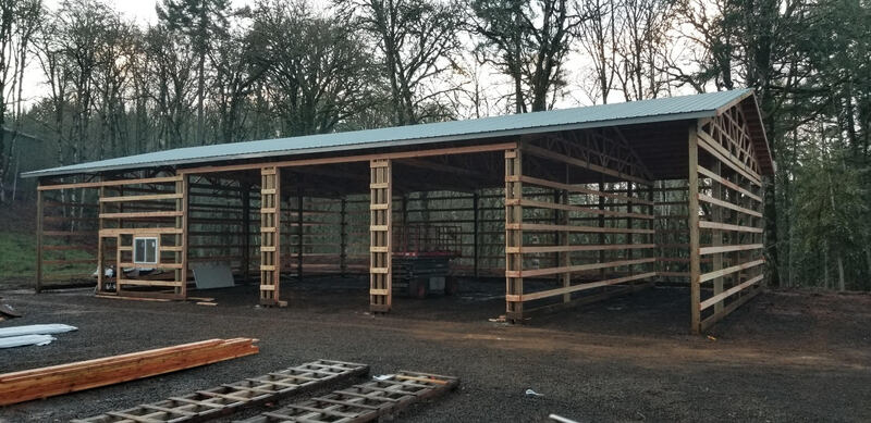 Picture of a pole barn in the process of construction.