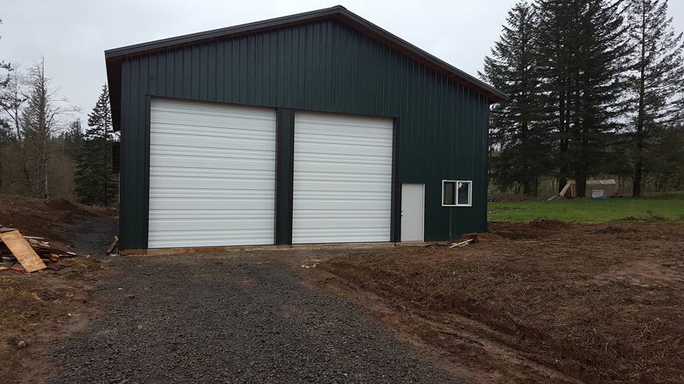 Front of a large storage pole barn with two overhead doors and a man door.